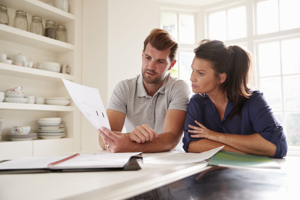 Couple Looking At Domestic Finances At Home Together