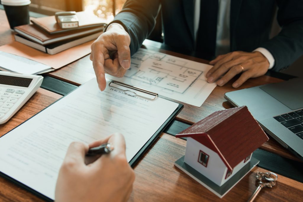 Insurance brokers are pointing to insurance contract signing and are explaining to customers at the office.