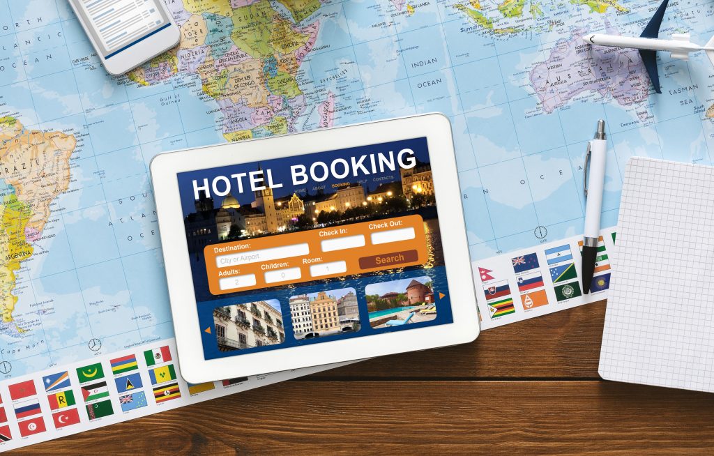 Hotel Booking Background. Digital Tablet With Application For Travel Accommodation Search Lying On Desk With Travel Map. Collage, Above View