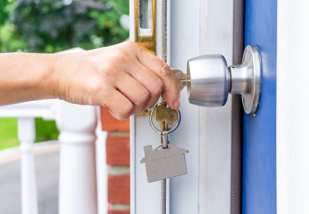 woman hand opening a door with keys