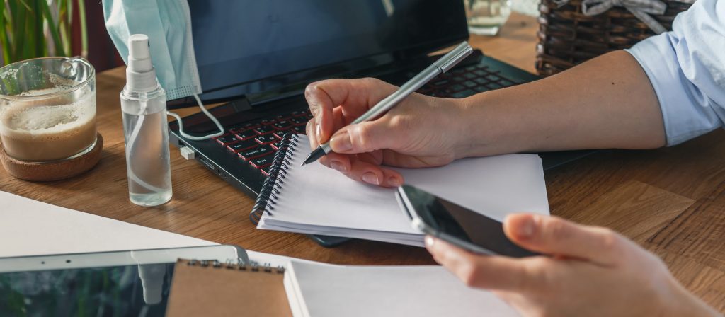 Home budget financial planning in crisis. Woman quarantined and working, planning home budget, lockdown covid 19. Business woman holding a pen and press calculator for calculating financial report,
