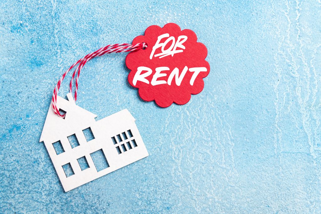 House for rent label on christmas holidays. Wooden house symbol with rent tag on blue background. Real estate, rental housing, rent for winter holidays concept. Top view