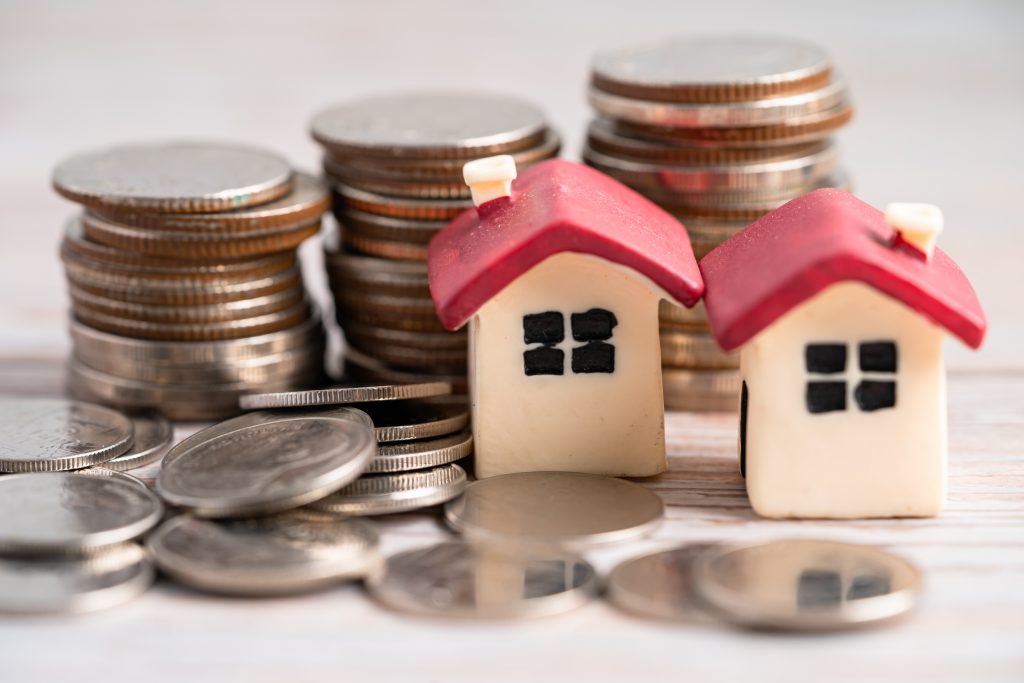 House model on credit card, coin and calculator, installment payment concept.