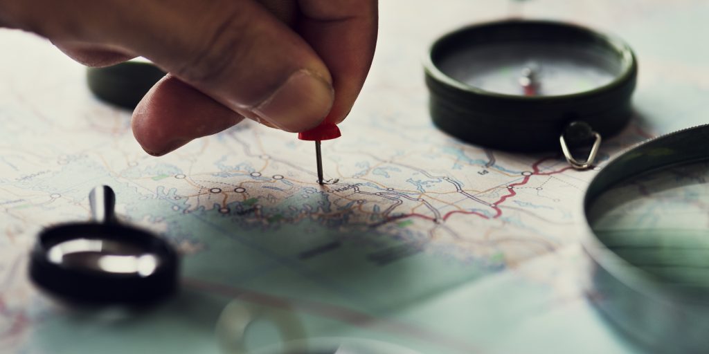 Closeup of hand pinning on world map journey travel