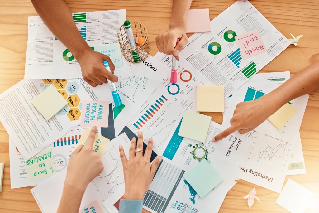 Planning, documents and strategy with hands of business people in meeting for research, investment .