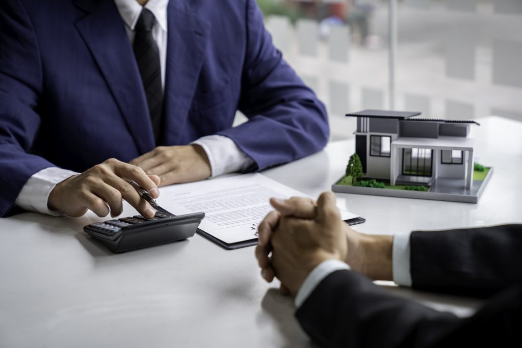 Negotiating home purchase prices, employment contracts, real estate agents, contract documents, home loan insurance and approving purchases for customers with house designs and keys on the table