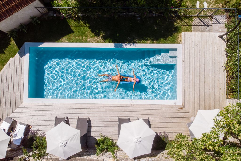 couple of men and women in a swimming pool of a luxury vacation home in Ardeche France Europe.