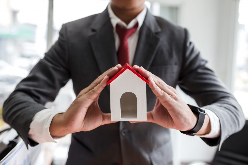 Real estate agent with house model.