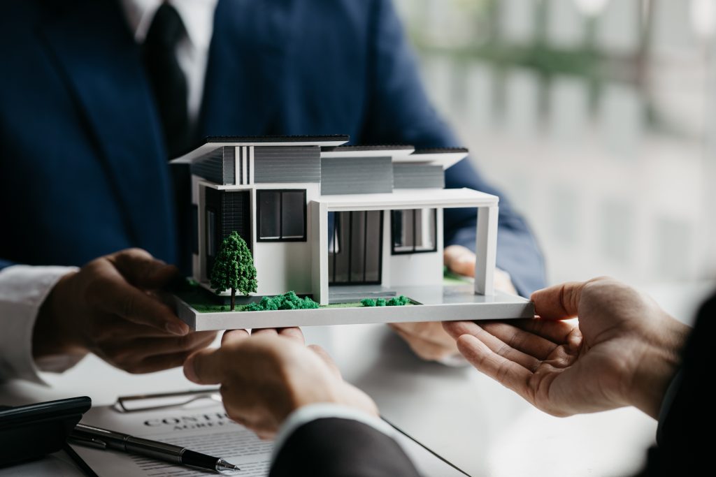 Real estate agents are carrying a housing model of the project to be forwarded to customers as home delivery. Real estate trading ideas and bank loans for buying and selling houses and land.
